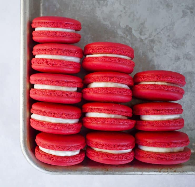 Stacks of red velvet macarons on a tray