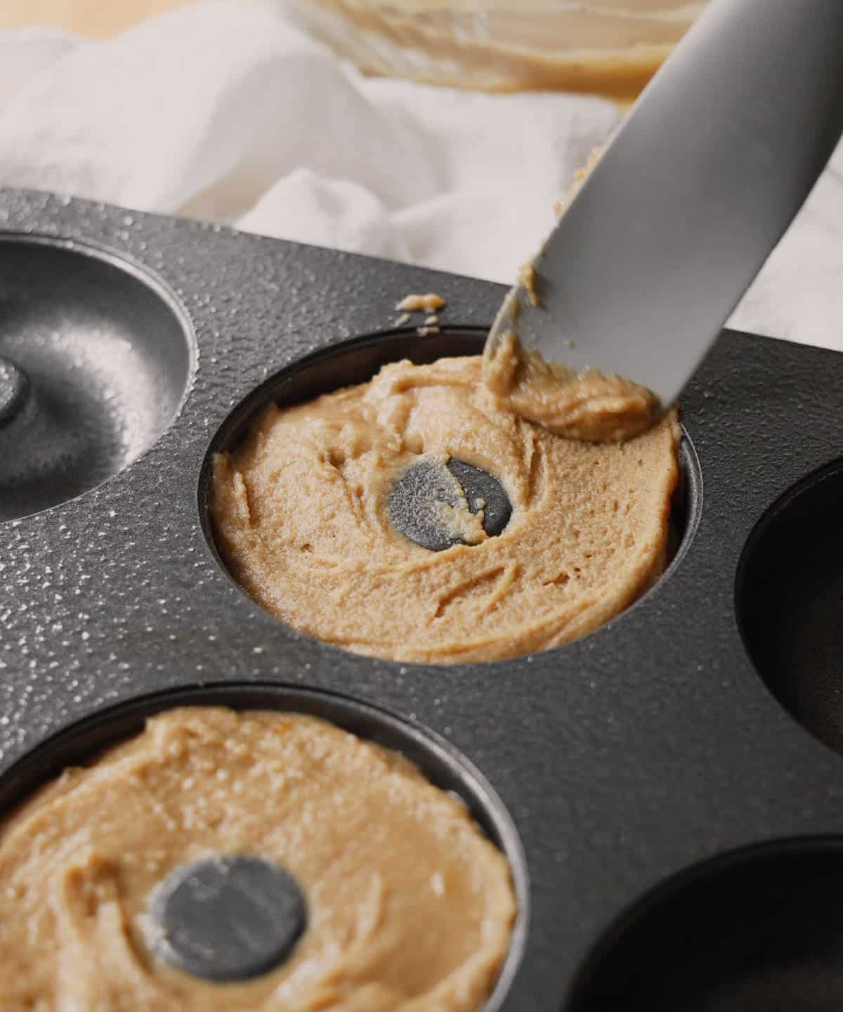 Spreading mochi donut batter into donut pan.