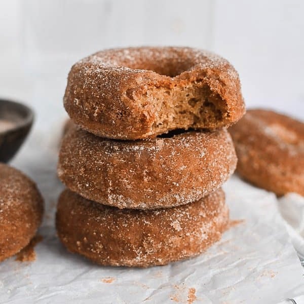 Cinnamon sugar mochi donuts stacked on top of one another.