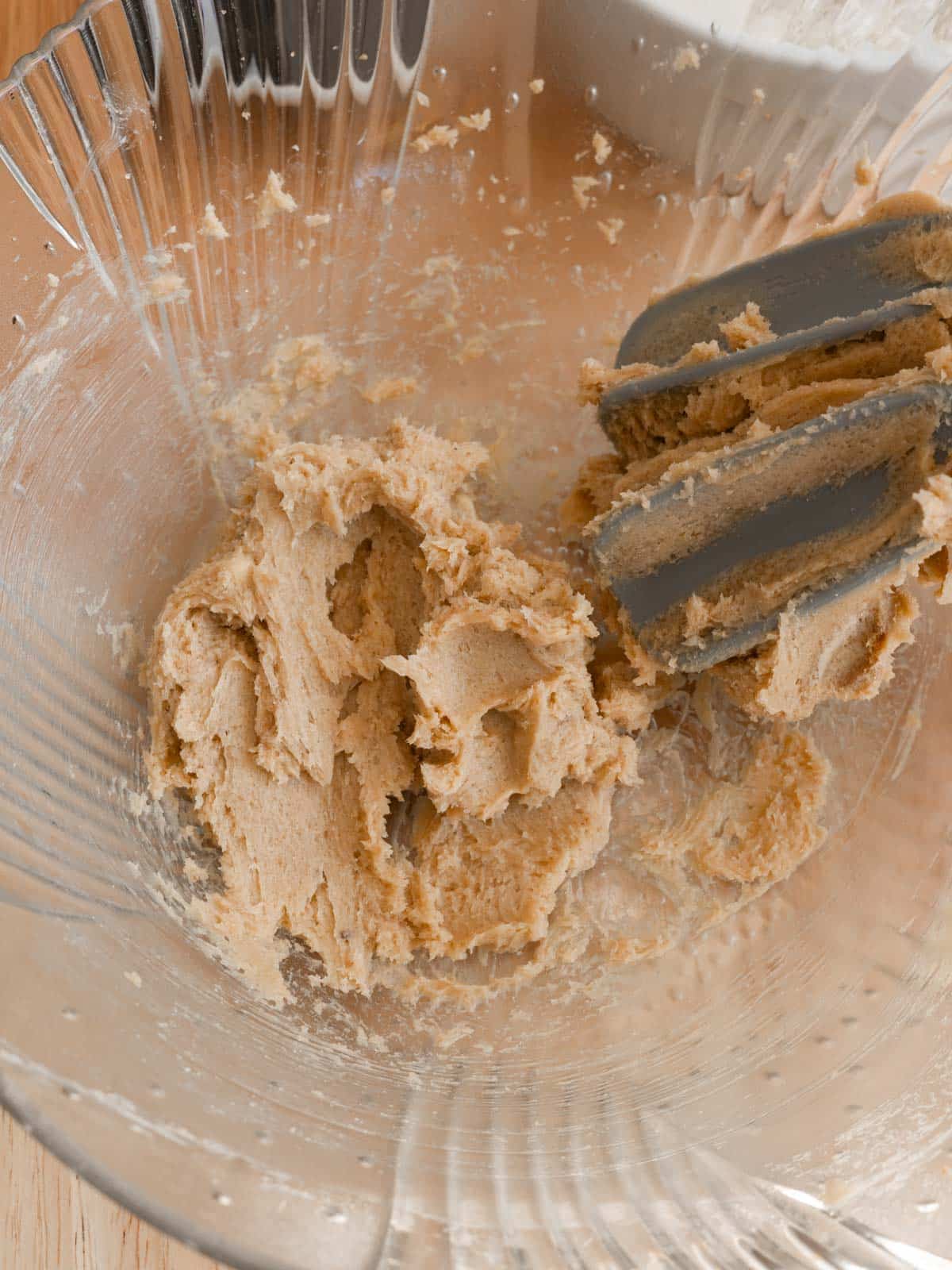 Creamed butter and brown sugar in a glass mixing bowl.