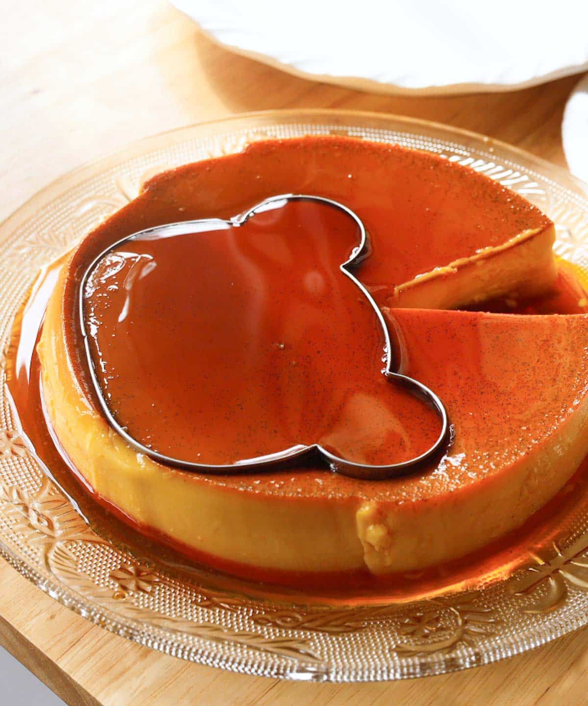 Bear cookie cutter inserted into leche flan.