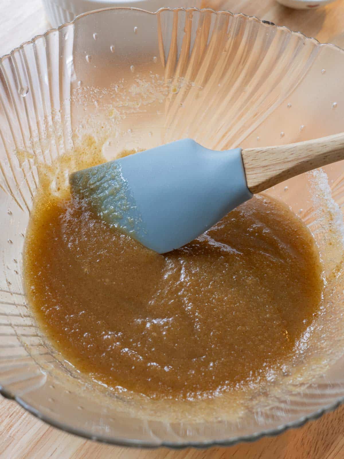 Butter and sugars mixed together in glass bowl.