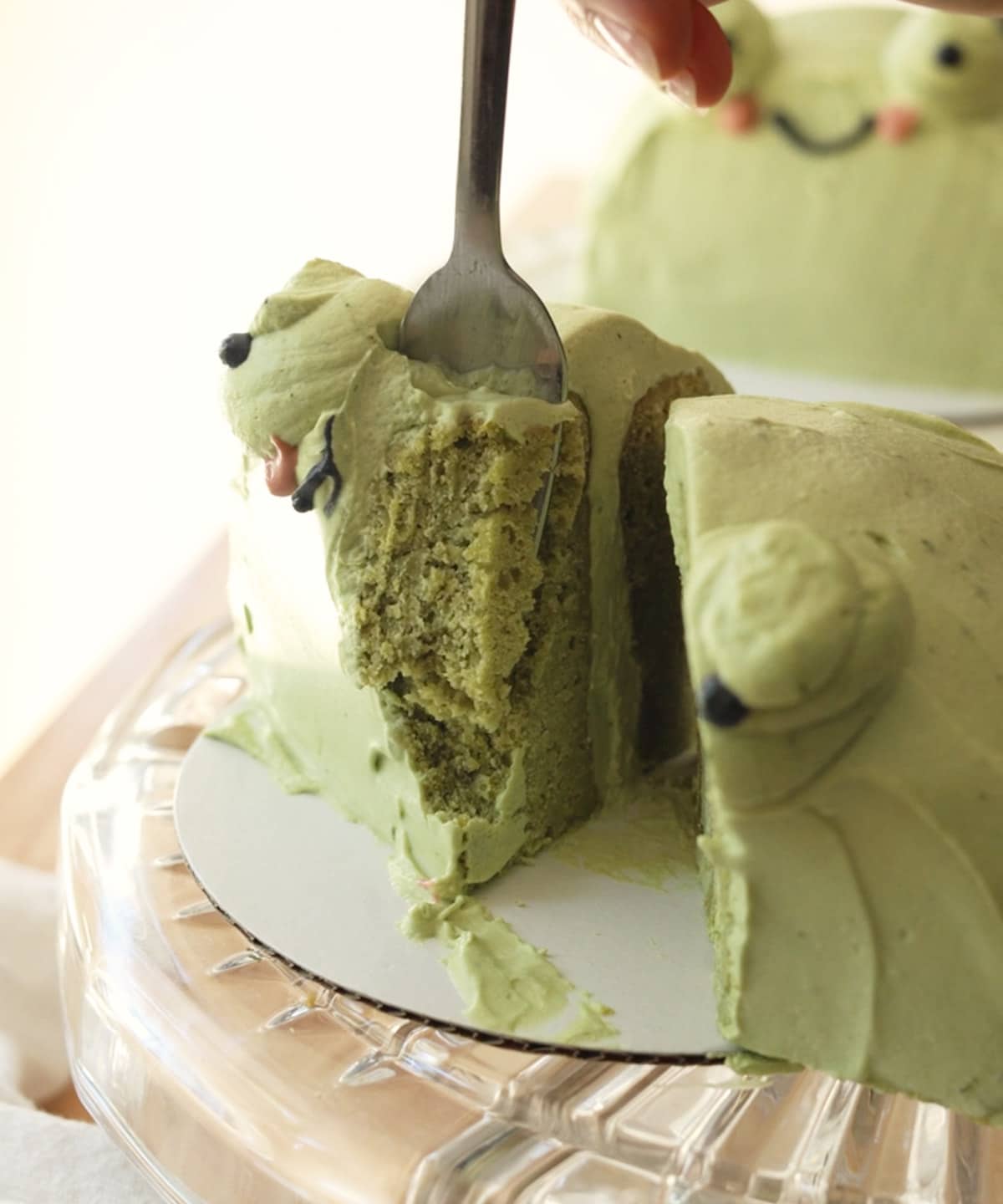 Using a fork to take a piece of the frog cake.