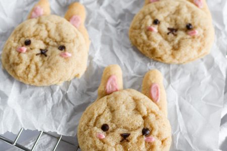 Bunny cookies on a piece of parchment paper over a wire rack