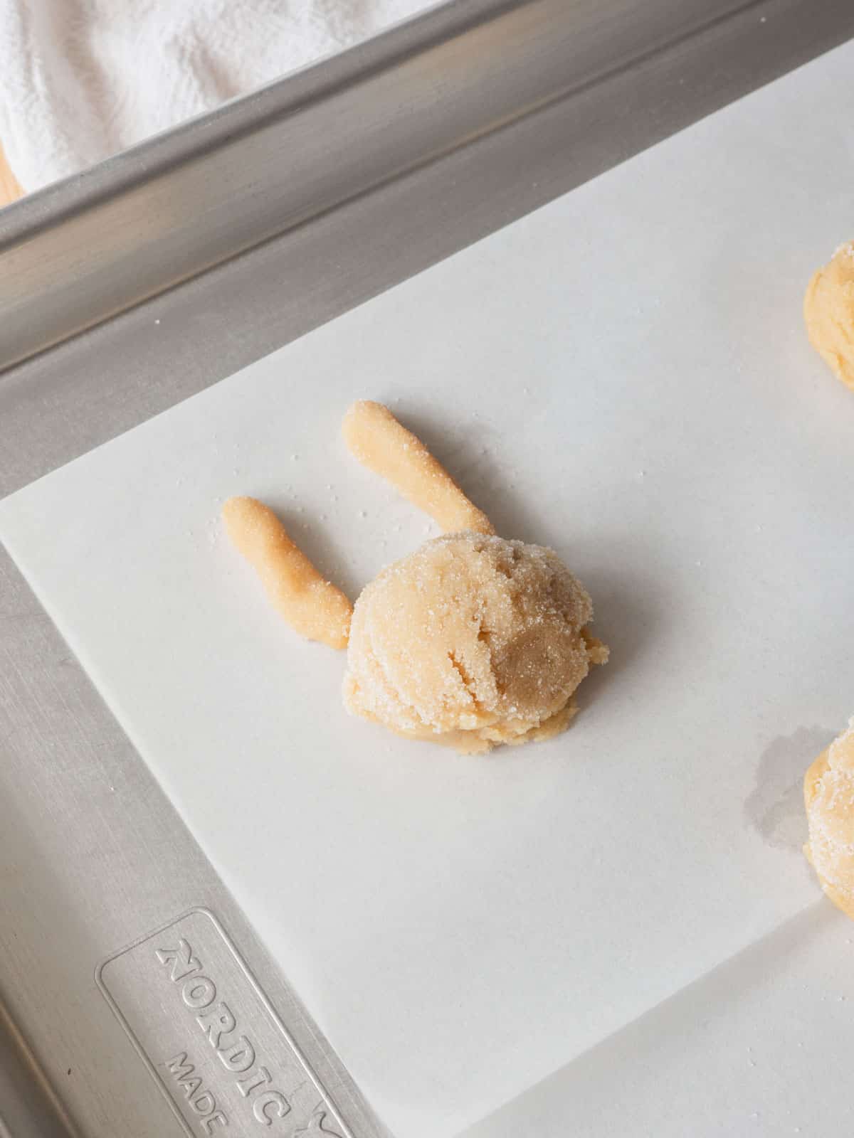 Bunny cookie dough on a lined baking sheet ready for the oven.