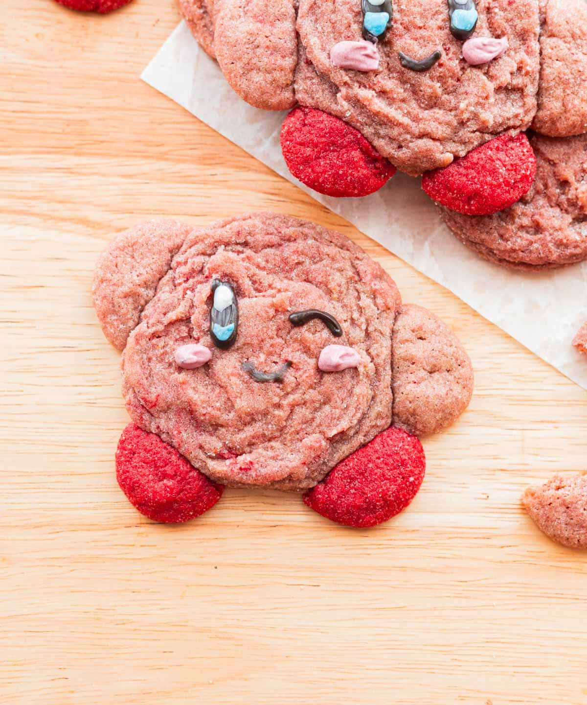 Baked strawberry kirby cookie with a winky face.