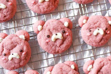 Pink strawberry bear cookies on a wire rack