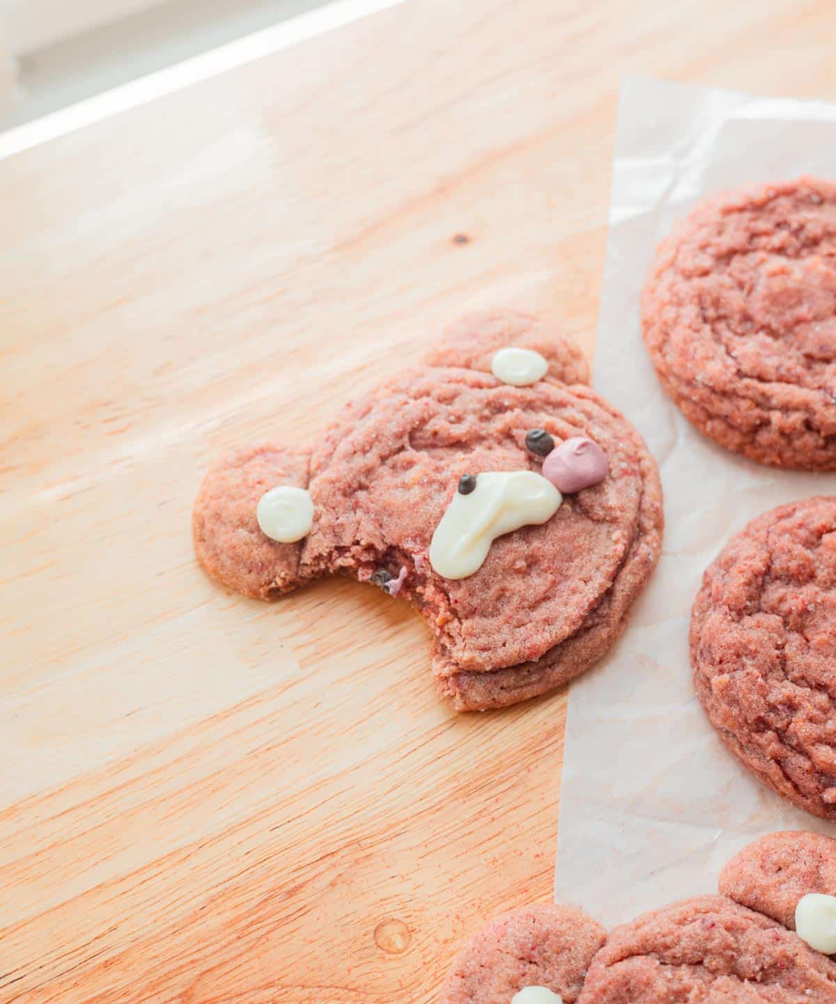 Strawberry bear cookie with a bite taken out of it.