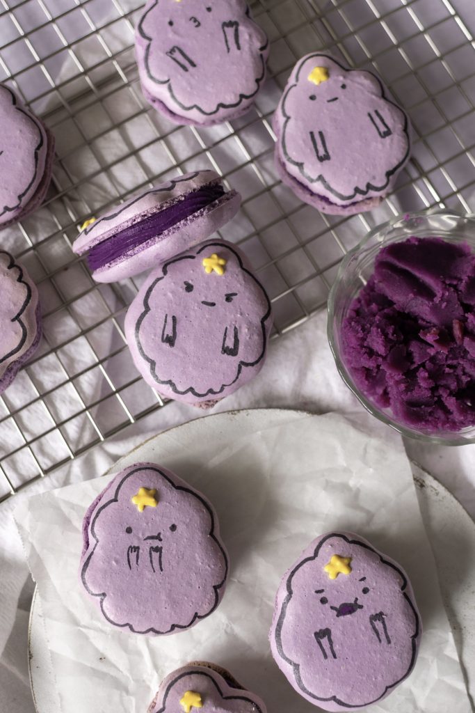 ube cheesecake lumpy space princess macarons on a wire rack w