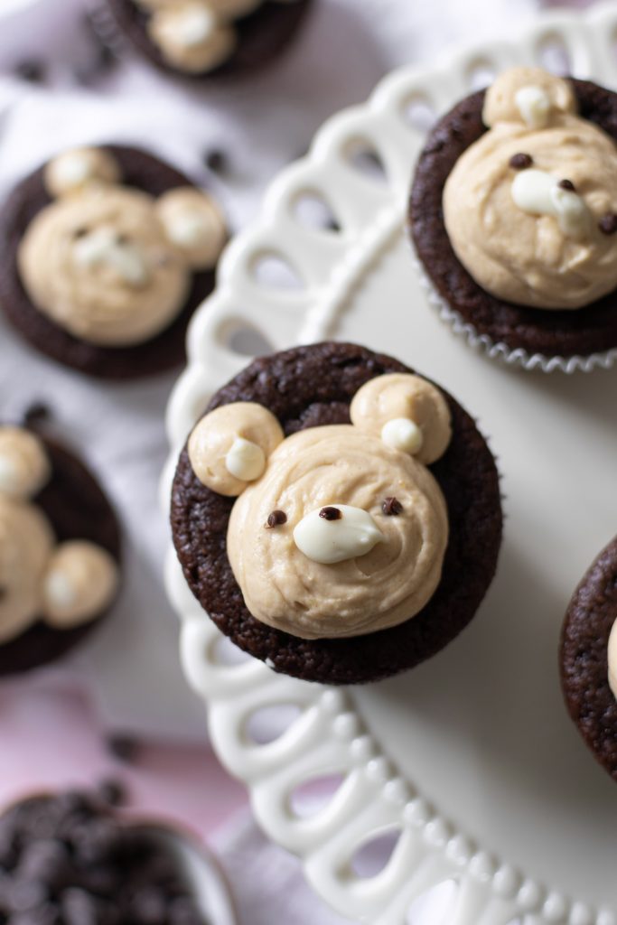 almond flour Chocolate bear cupcakes with peanut butter whipped cream frosting on cake stand