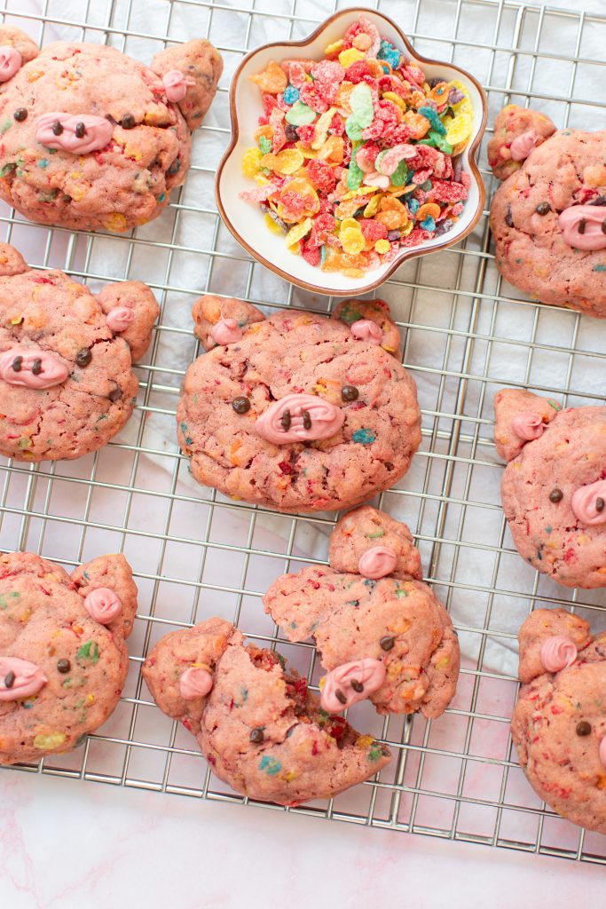 Fruity pebble pig cookies on a wire rack