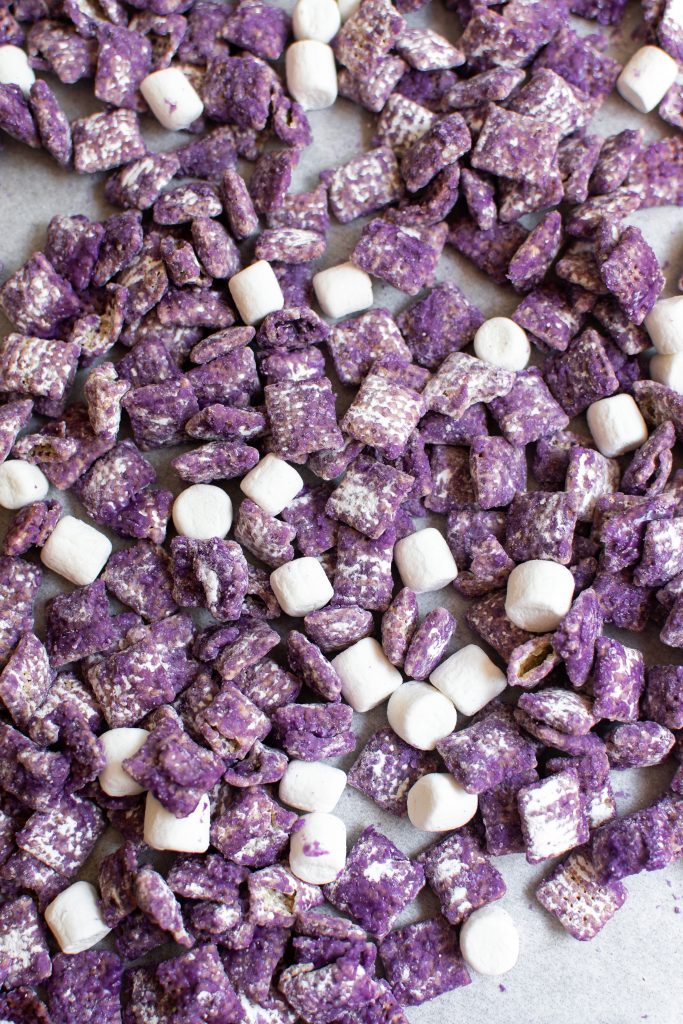 Spread of ube muddy buddies on parchment paper
