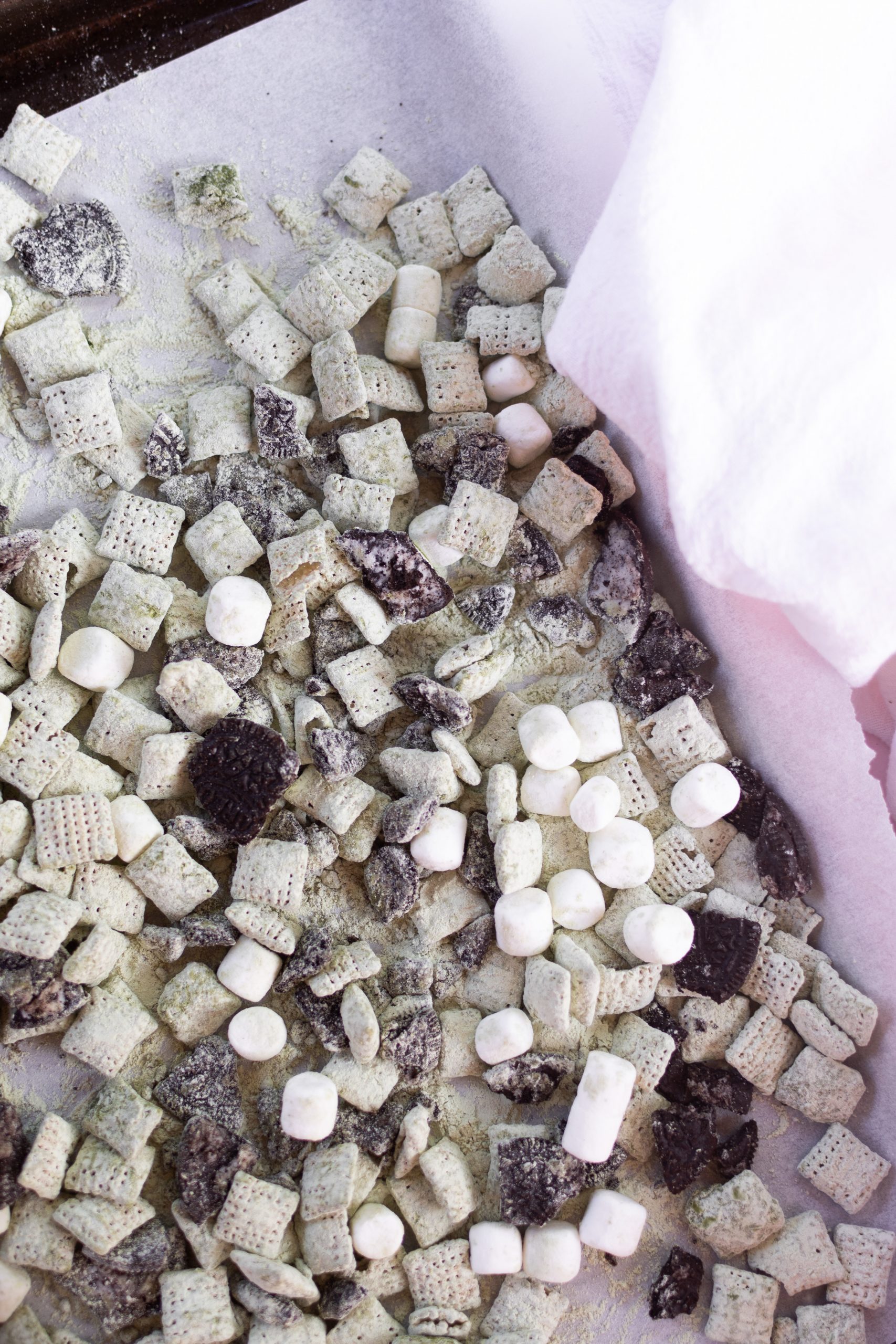 Oreo matcha puppy chow on parchment lined tray