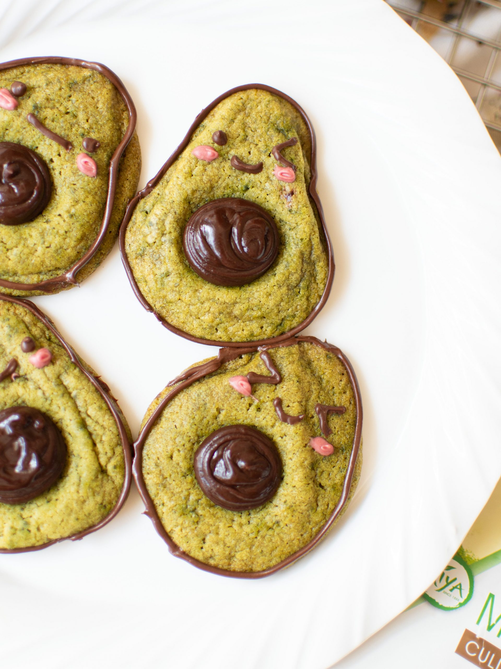 Cute avocado cookies on a white plate
