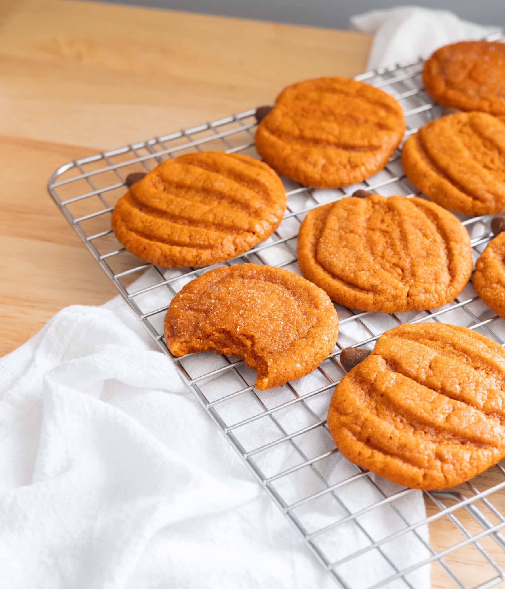 Bite shot of egg-free pumpkin snickerdoodles on a wire rack.