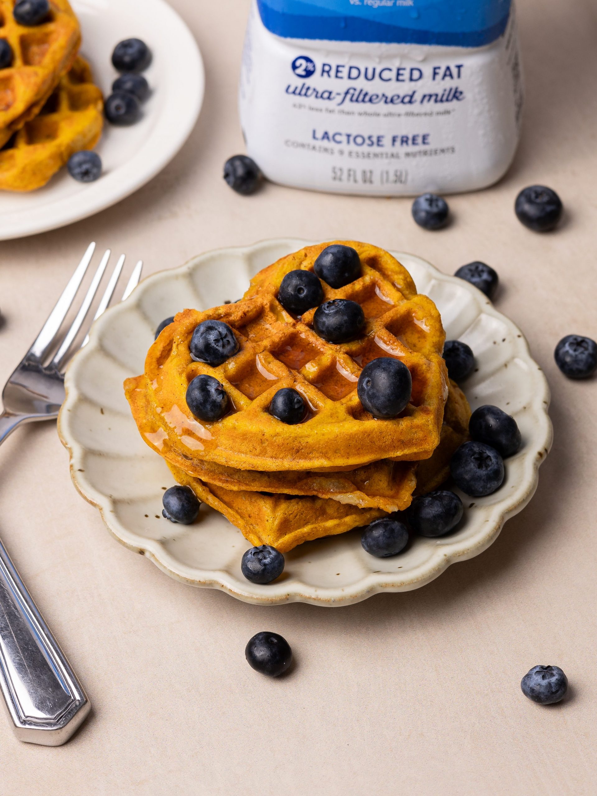 pumpkin waffles topped with maple syrup and blueberries