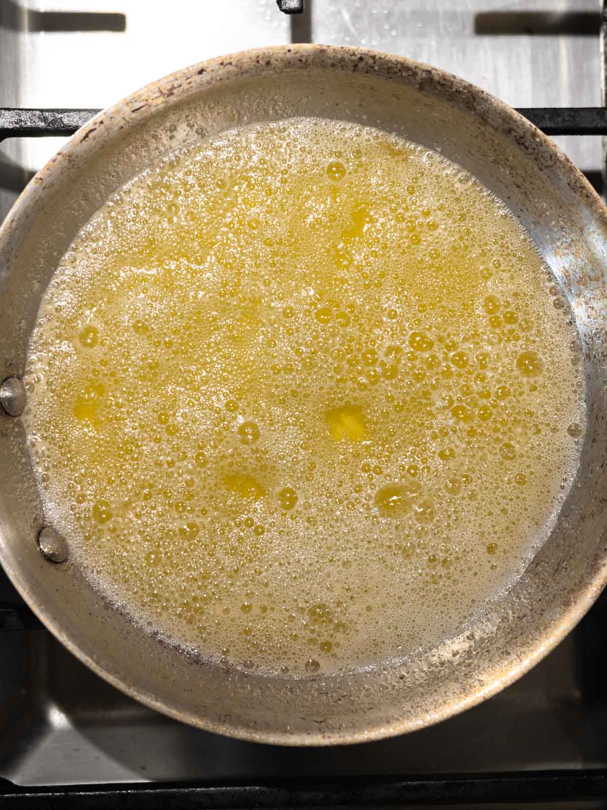 Butter being melted in a pan before it turns brown.