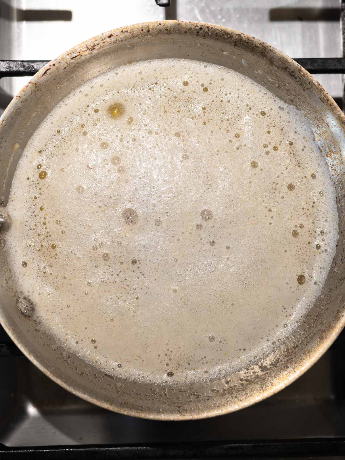 Butter melted with a layer of foam on the top of the pan.