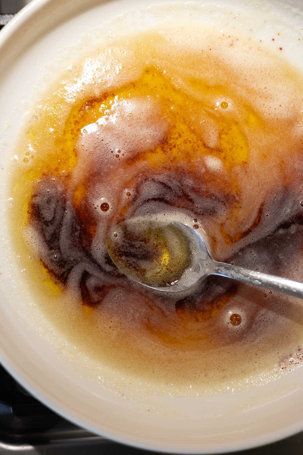 Brown butter in a bowl with a spoon. 