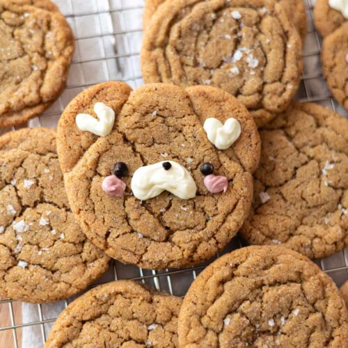 Brown butter espresso cookies on a wire rack, one is decorated as a bear.