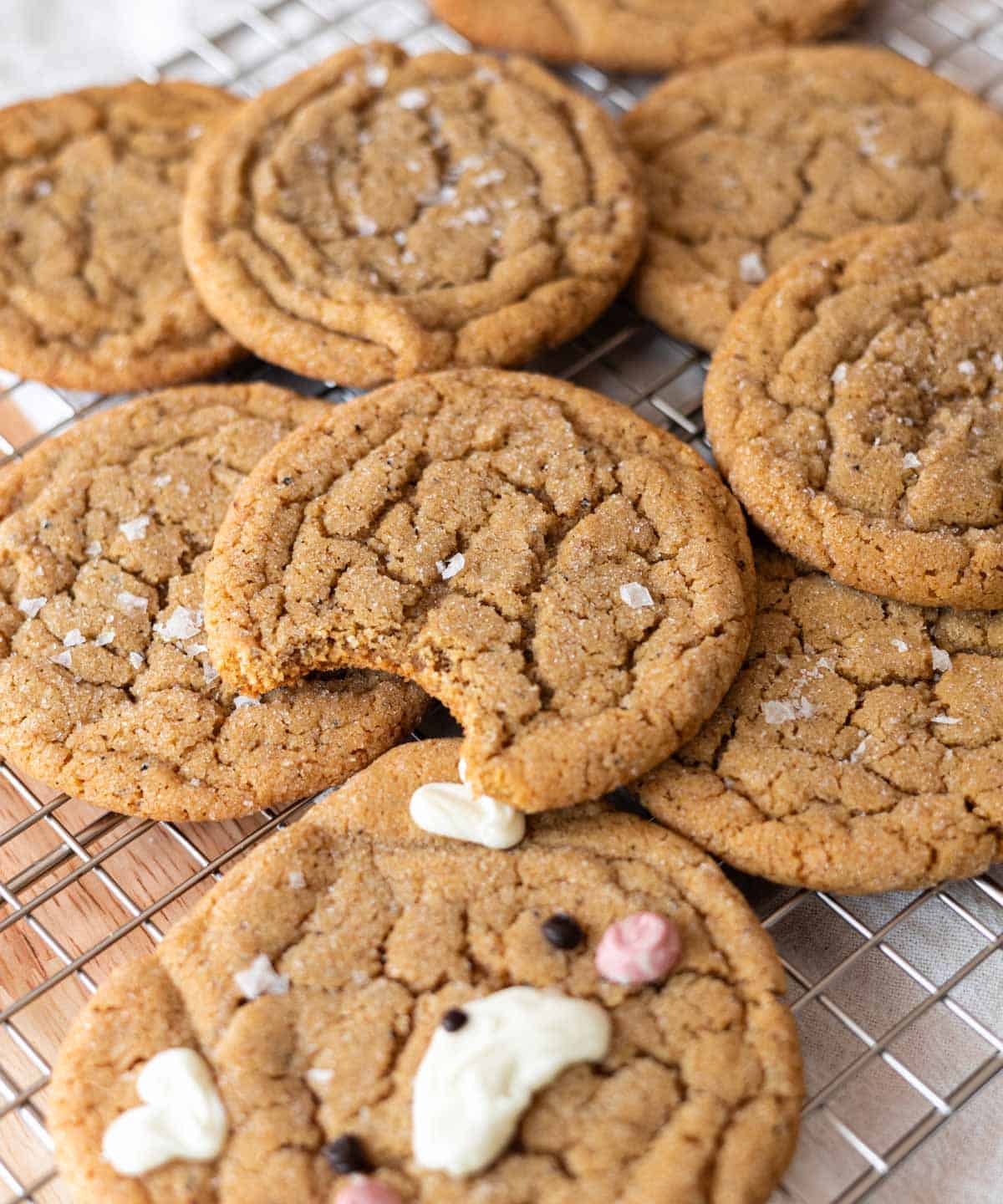 Brown butter espresso cookies on a wire rack; top cookie has a bite taken out of it.