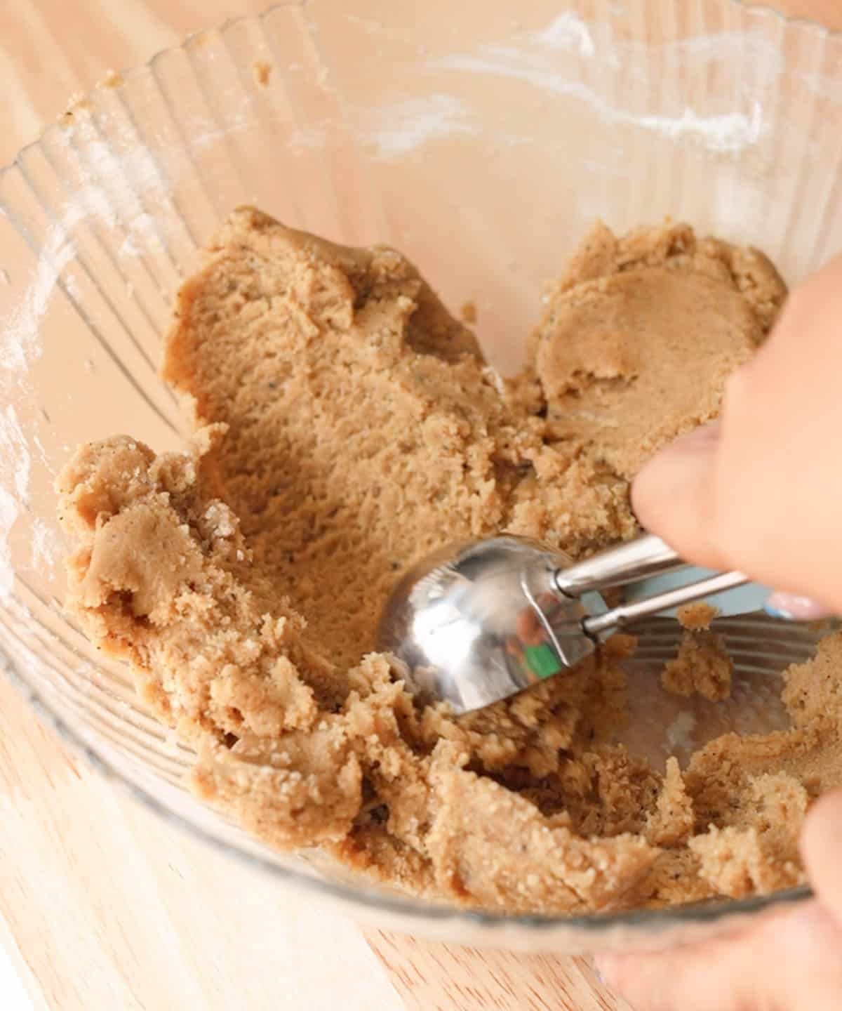 Using a cookie scoop to scoop batter.