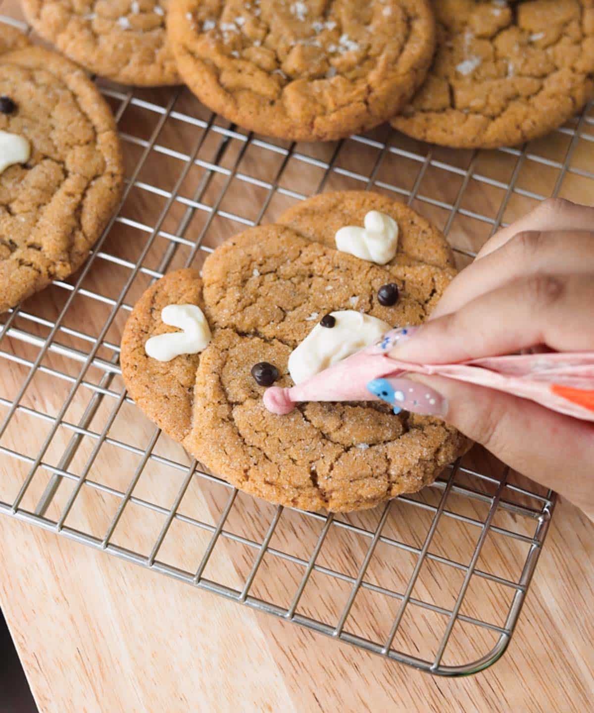 Decorating bear cookie face with melted chocolates.