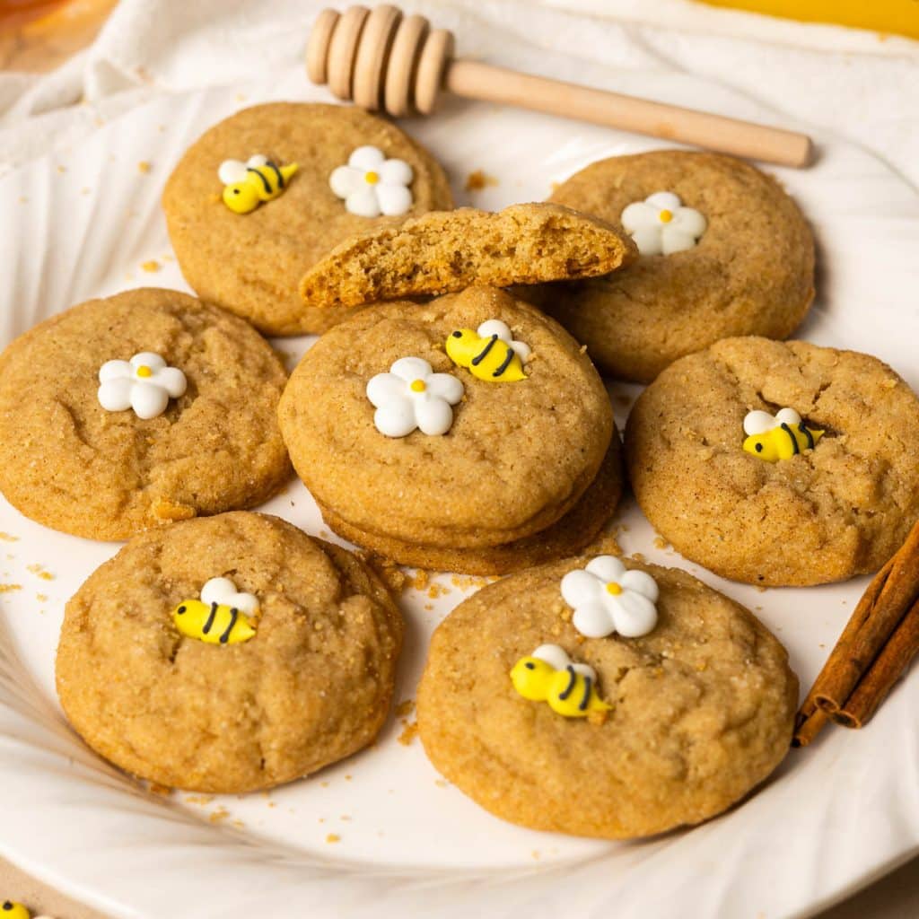 honey cookies on a white plate with bee sprinkles and daisy sprinkles