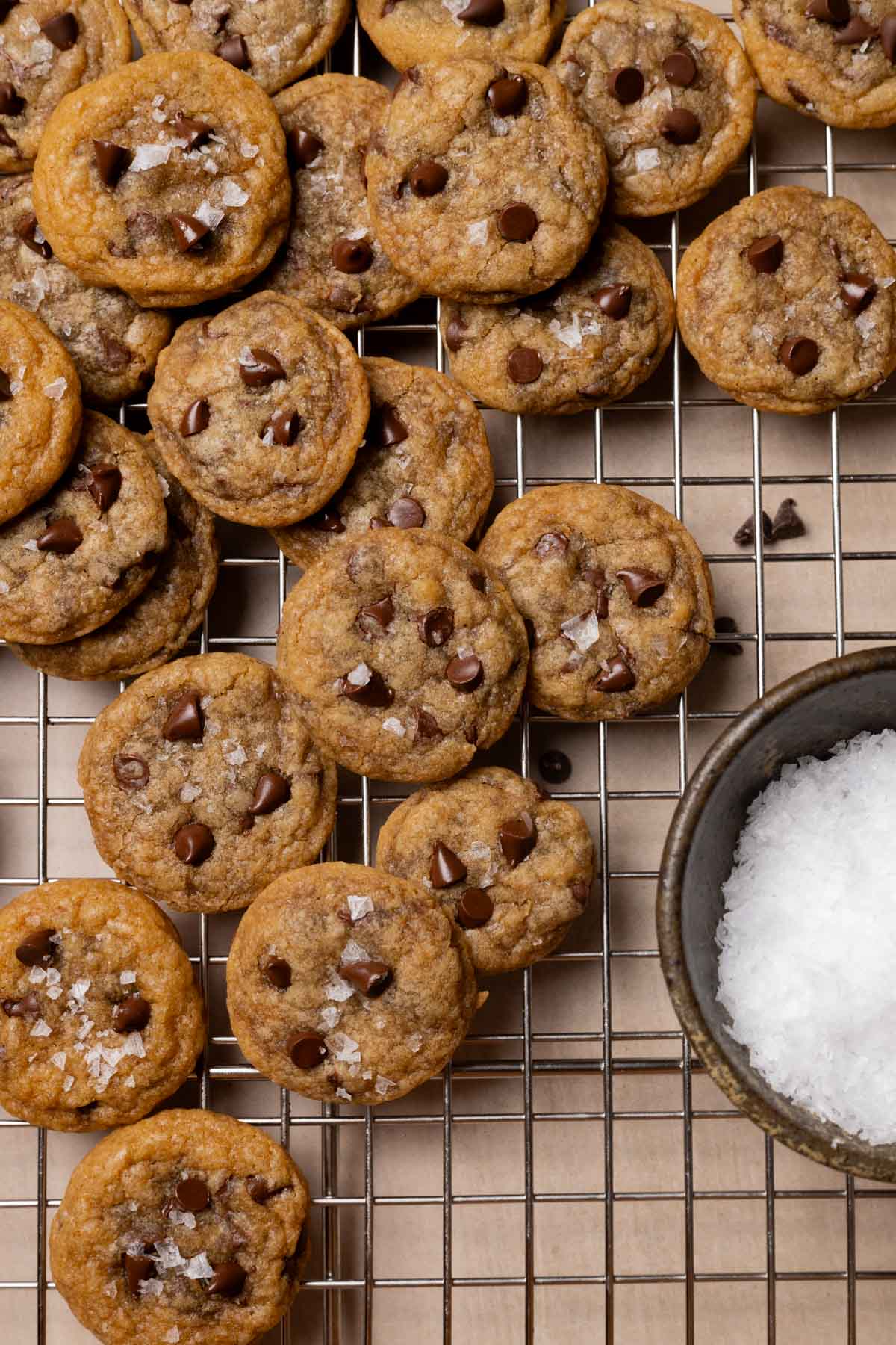 mini cookies on a wire rack next to a bowl of sugar.