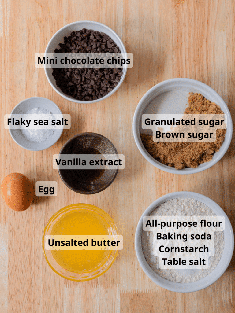 Mini chocolate chip cookie ingredients labeled on a wooden backdrop.