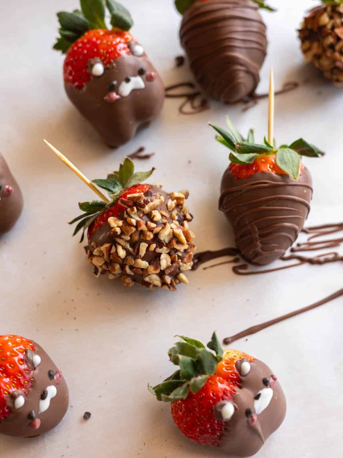 chocolate-covered strawberries with crushed pecans and chocolate drizzle.