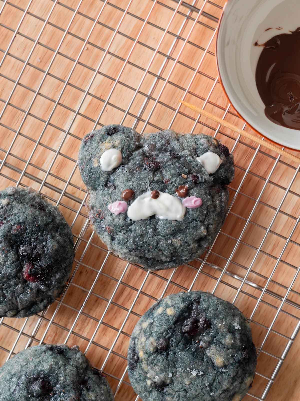 Blueberry cookie decorated as bear on wire rack.