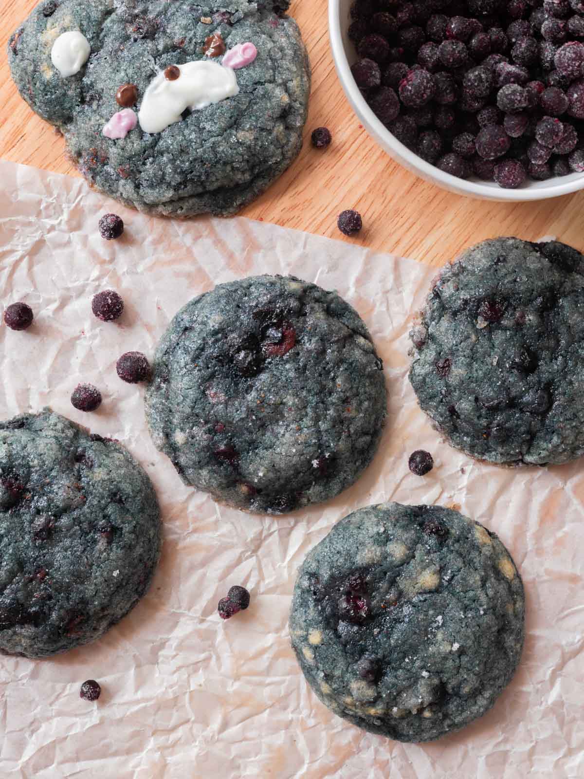 Blueberry cookies on parchment paper on table.