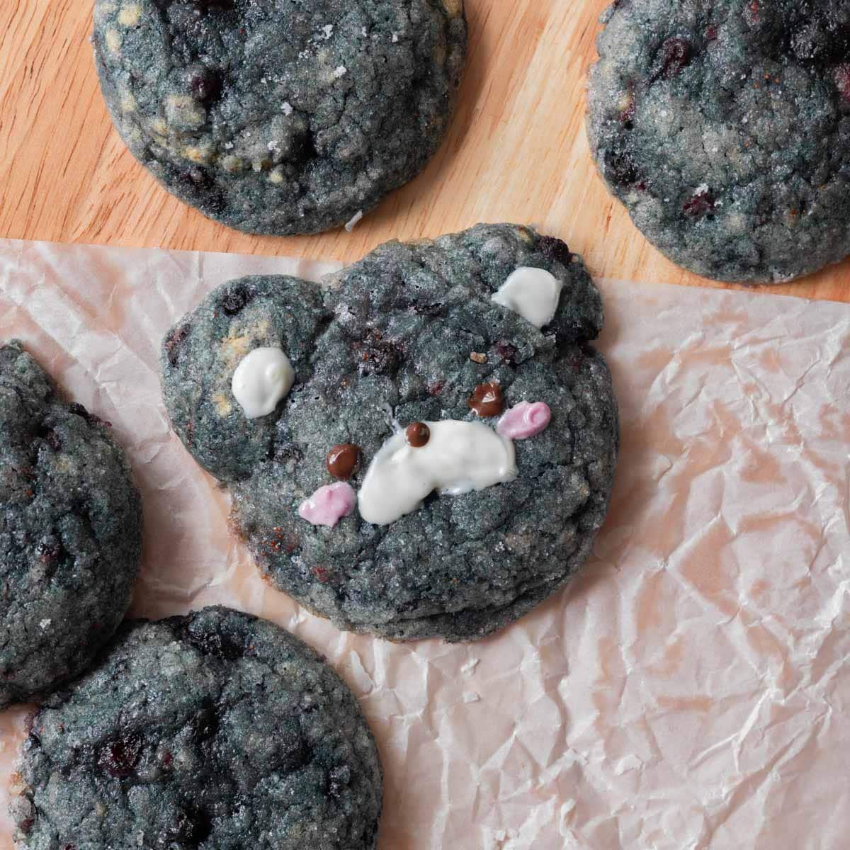 Blueberry cookies on parchment paper on table.