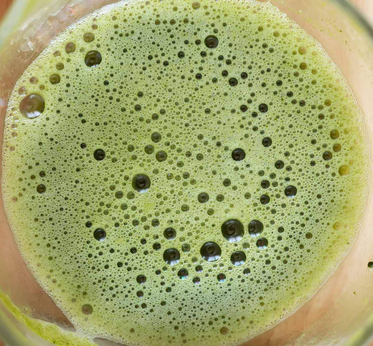 Frothy matcha powder whisked in hot water