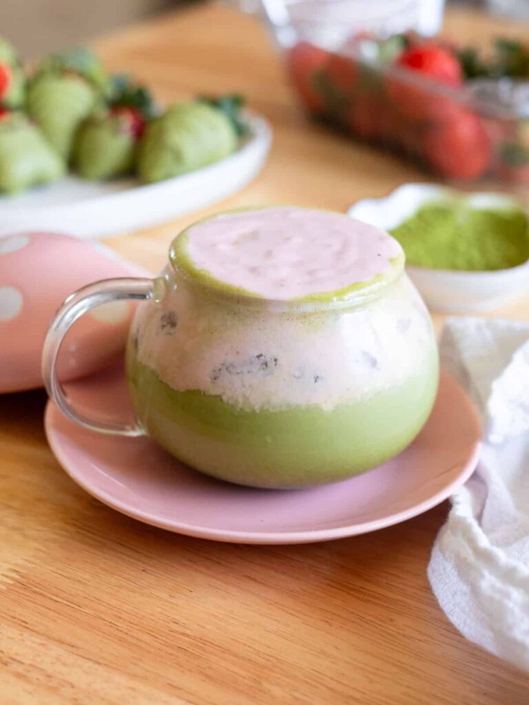 Matcha latte with strawberry cold foam in a glass mug; clicking on this image will open up to the recipe post.