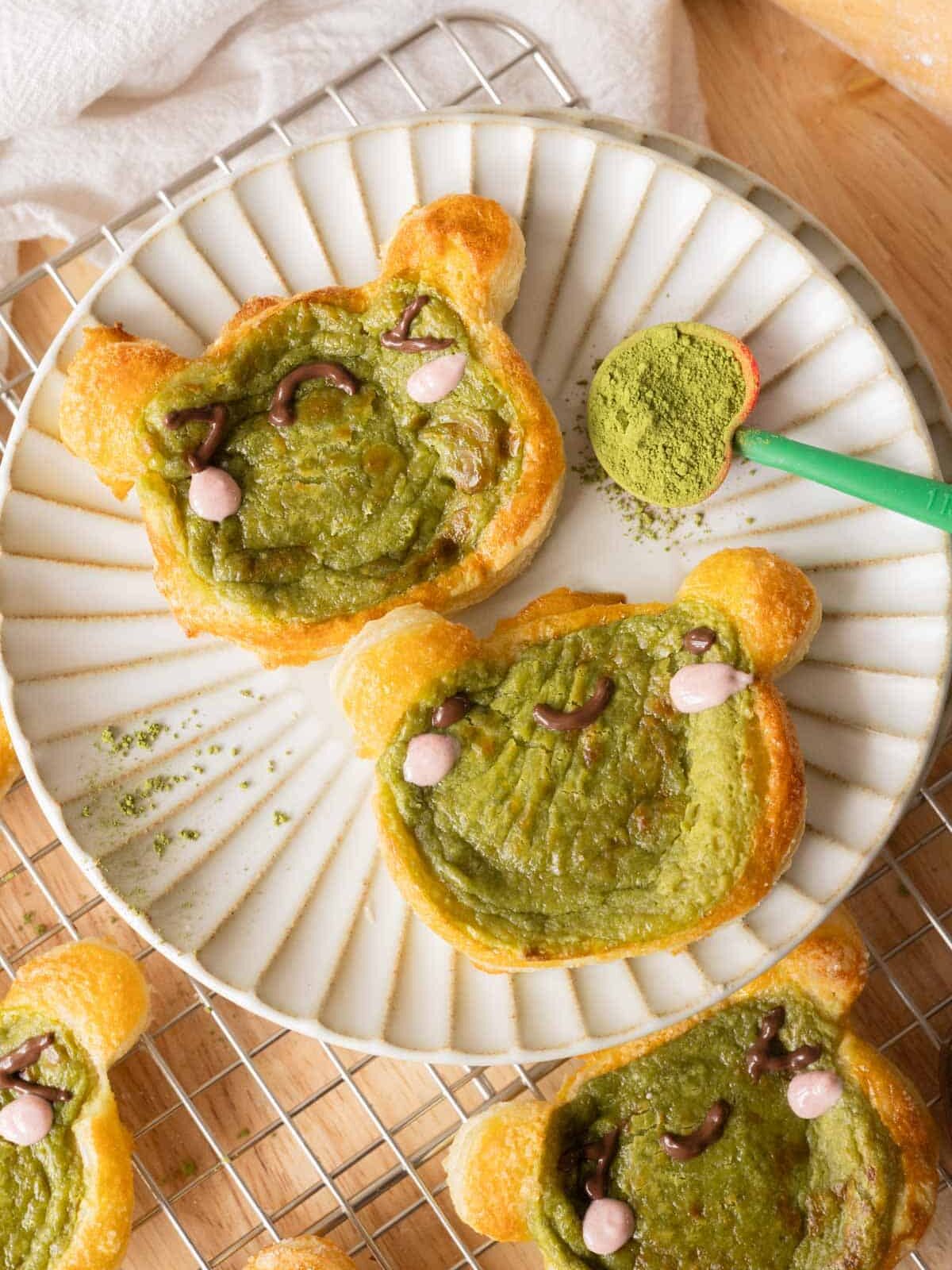 Frog matcha danishes on a plate.