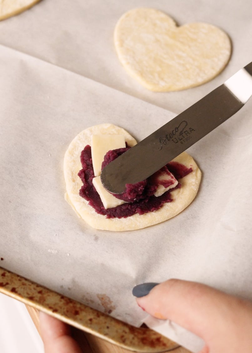 Spreading ube jam onto puff pastry.