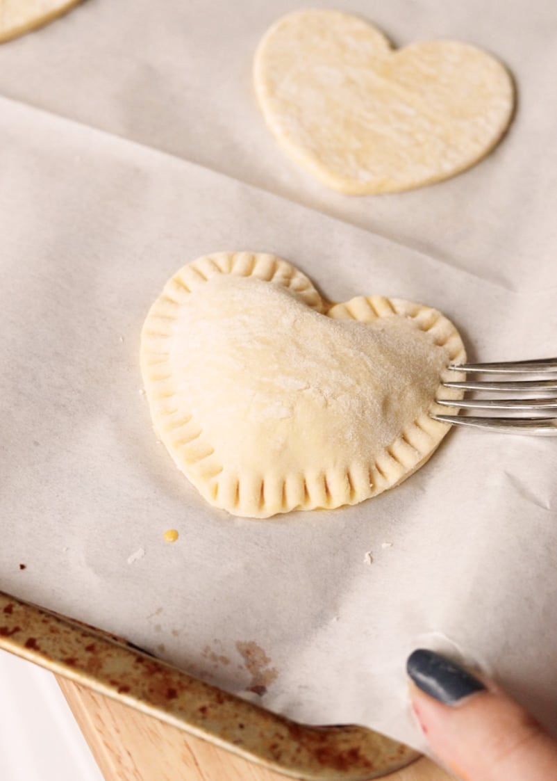 Crimping puff pastry with fork.