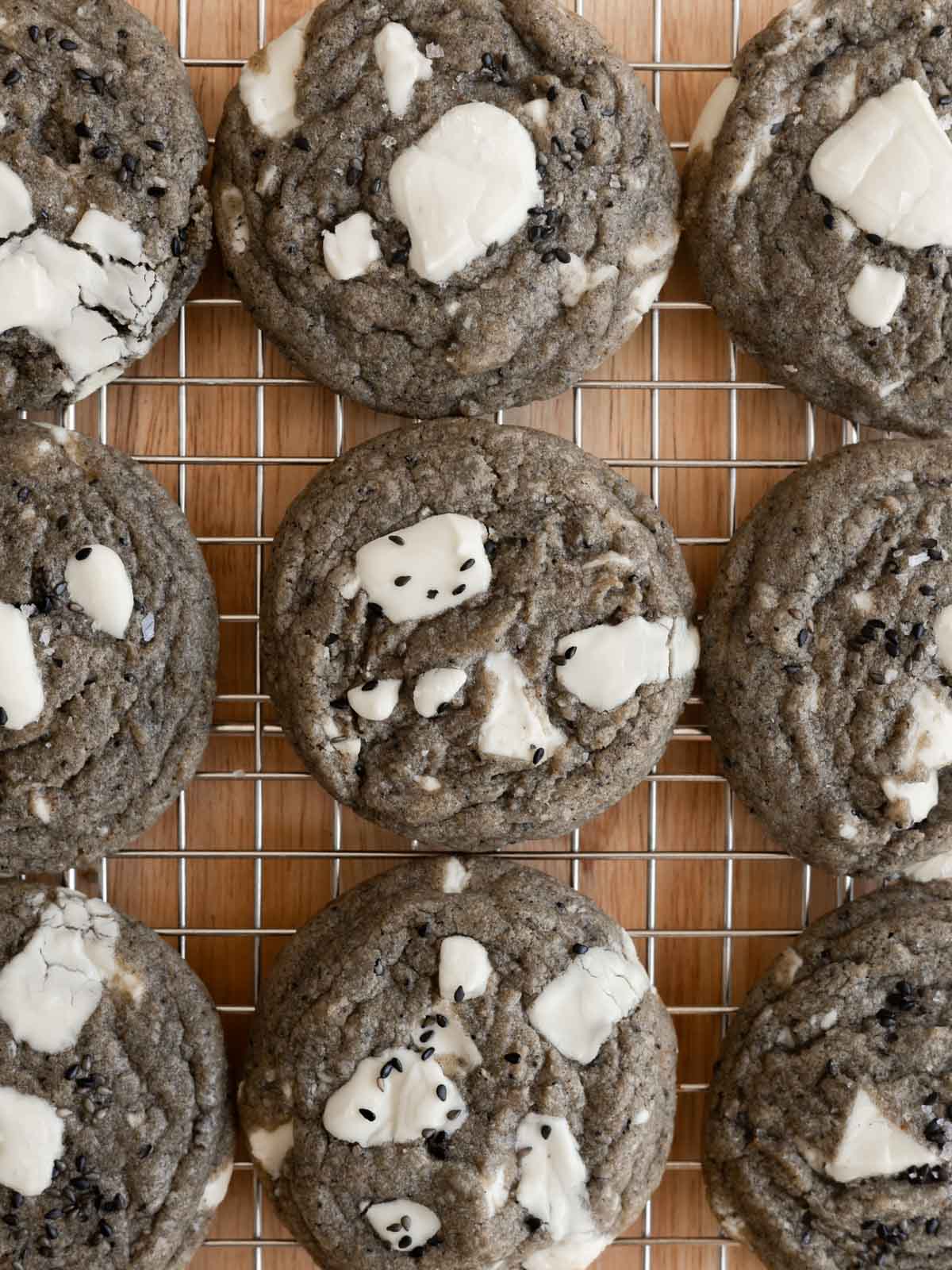 Freshly baked white chocolate black sesame cookies cooling on a wire rack. 