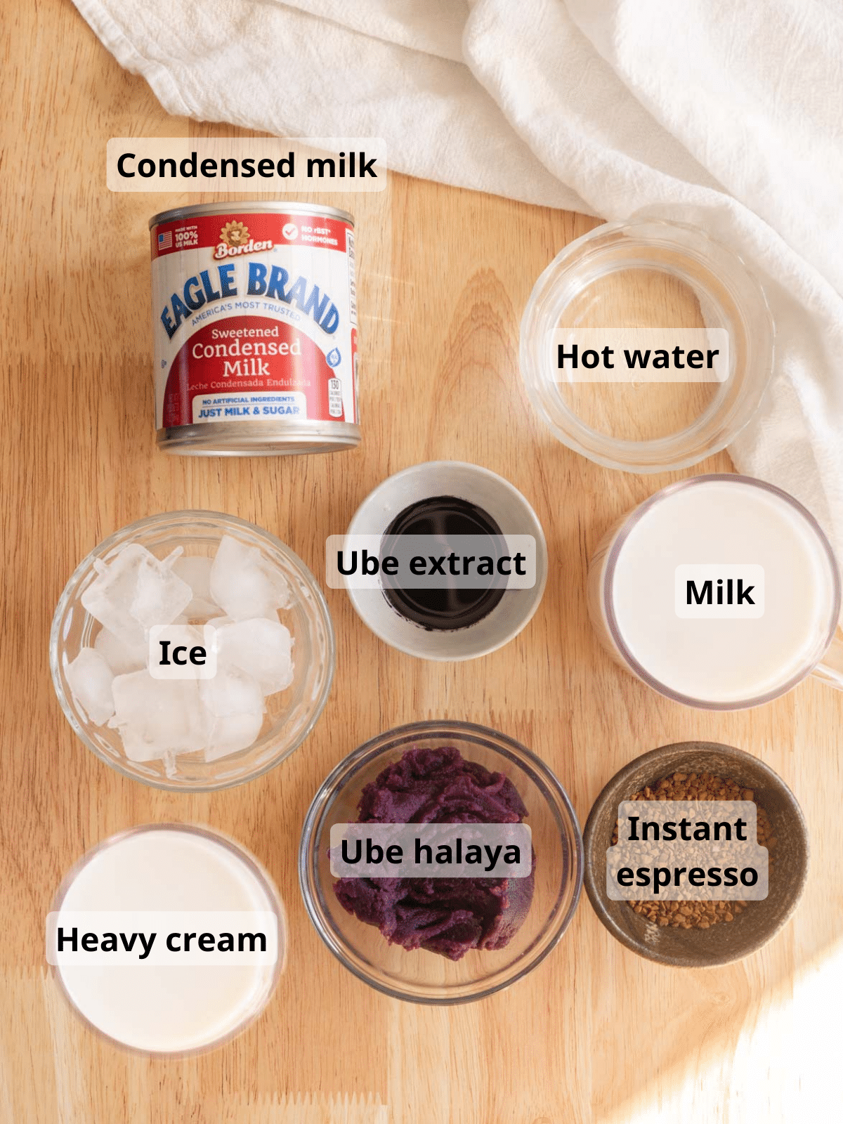 Labelled ube latte ingredients on a wooden backdrop.