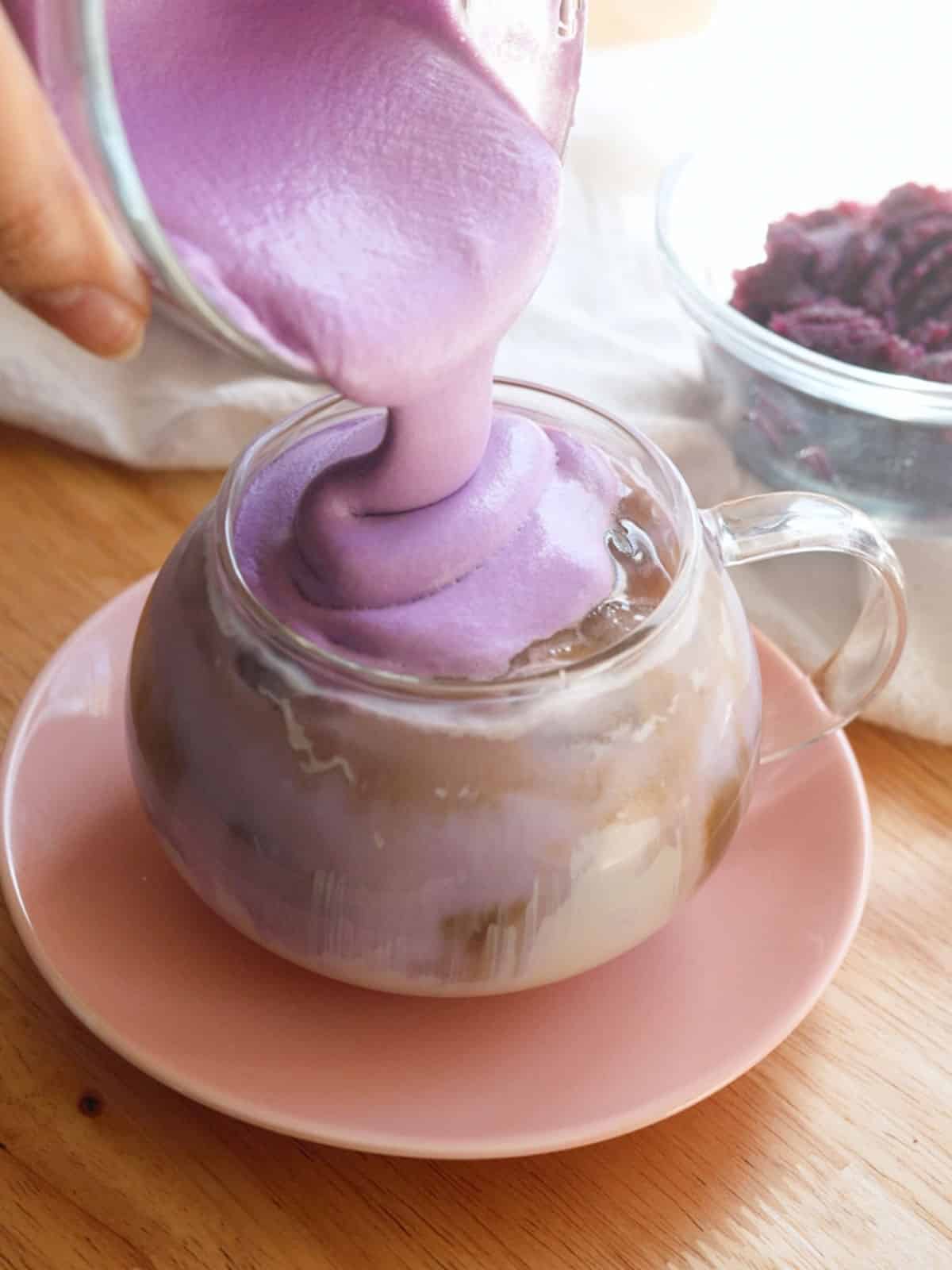 Pouring fluffy purple ube foam on top of ube latte.