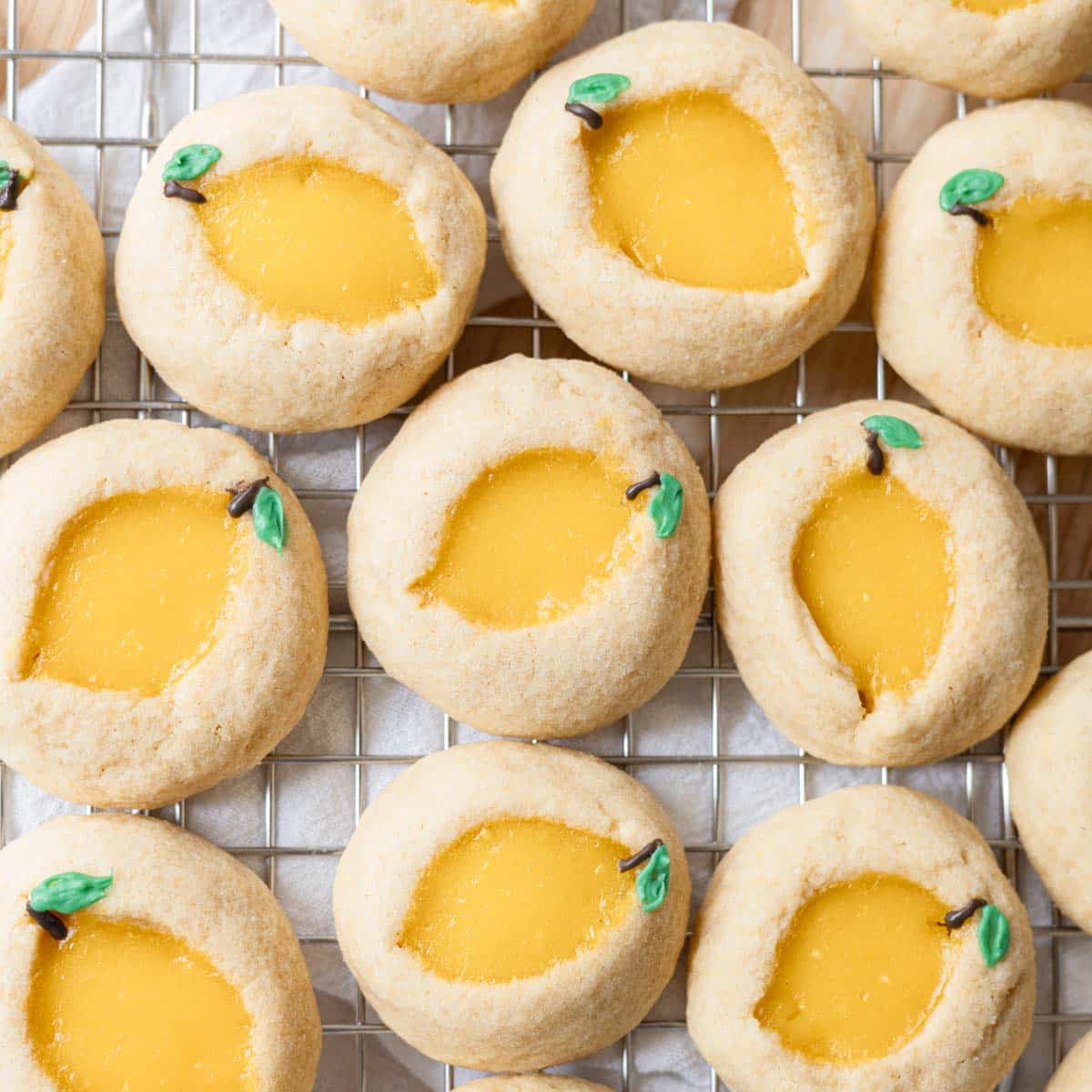 Baked lemon curd thumbprint cookies on a wire rack.