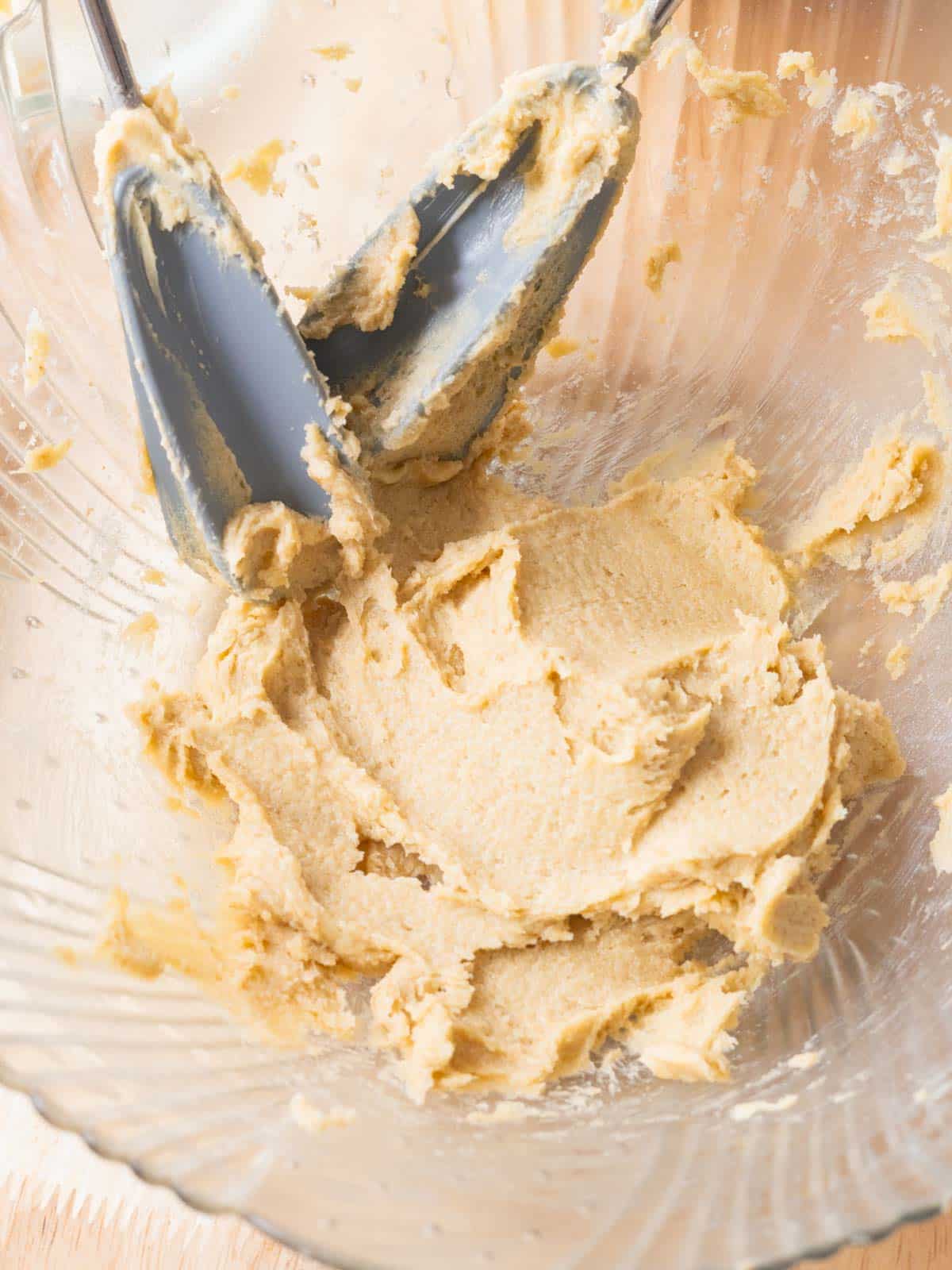 Glass mixing bowl with butter and sugars lightly creamed together.