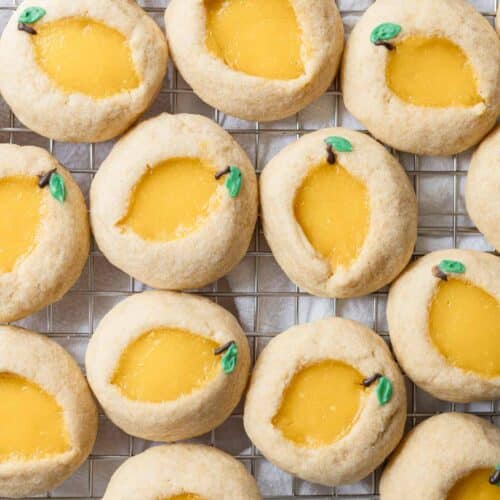 Baked lemon curd thumbprint cookies on a wire rack.