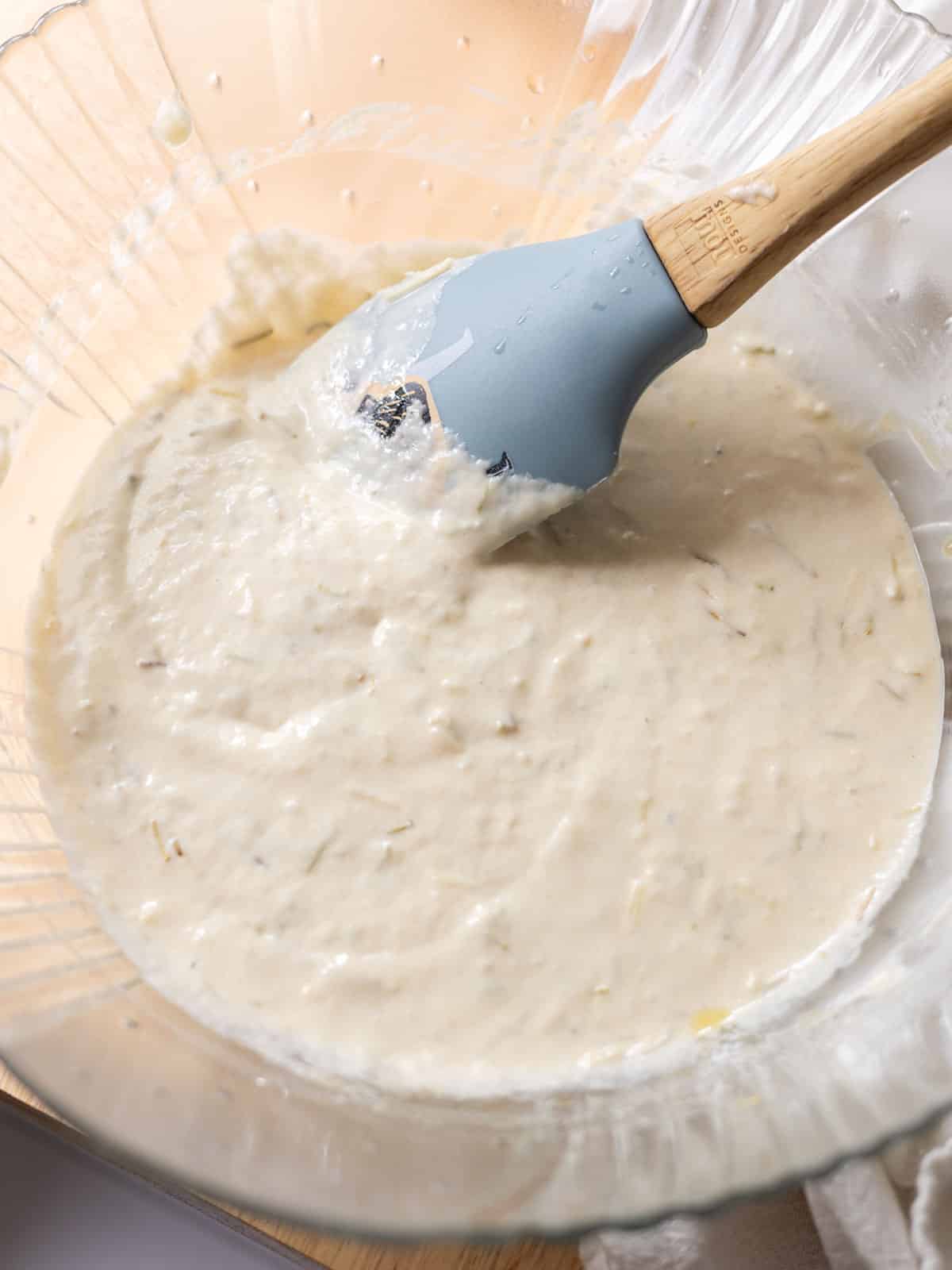 Glass mixing bowl of sourdough discard batter mixed together.