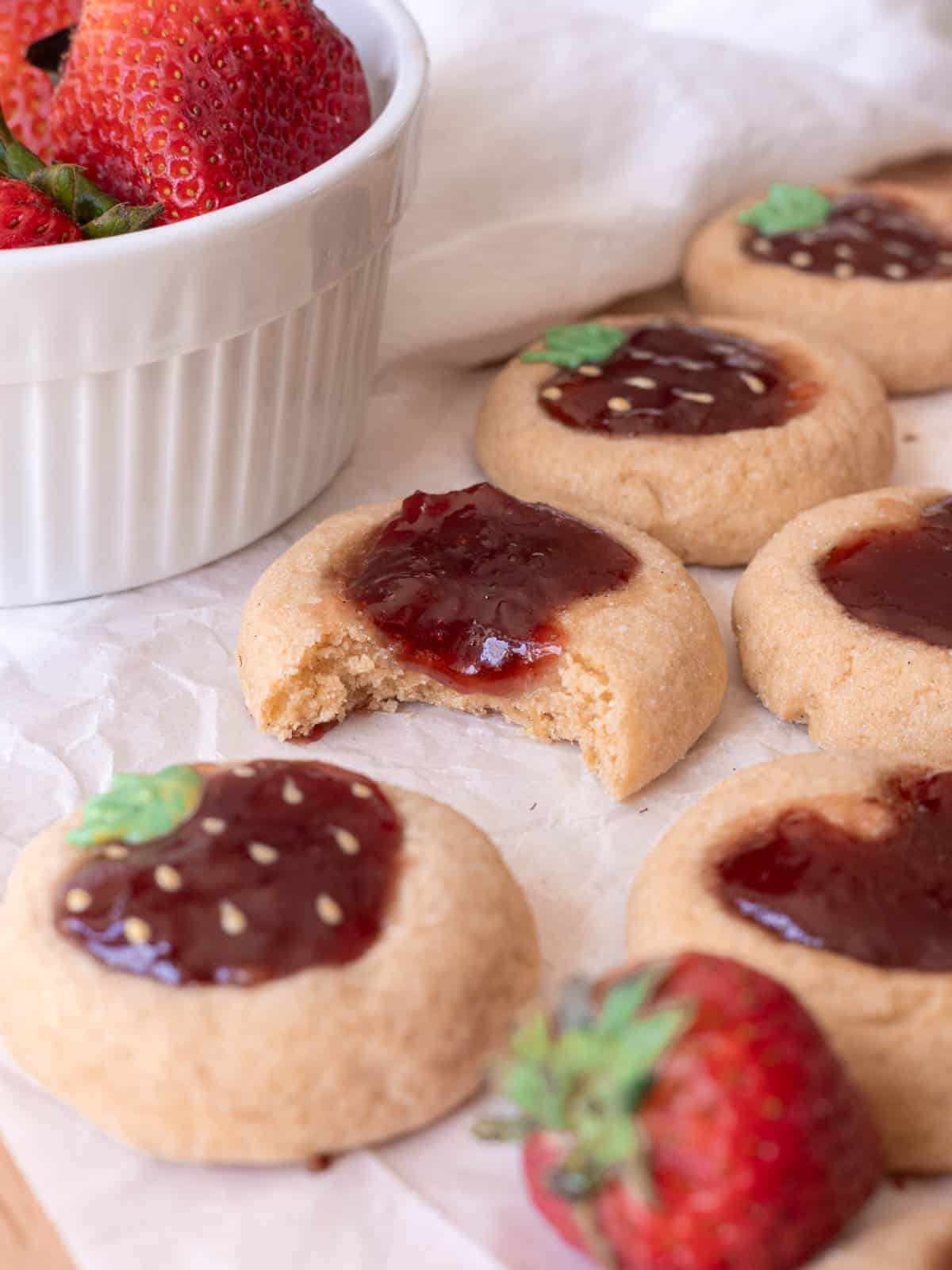 Strawberry thumbprint cookie with bite taken out of it.