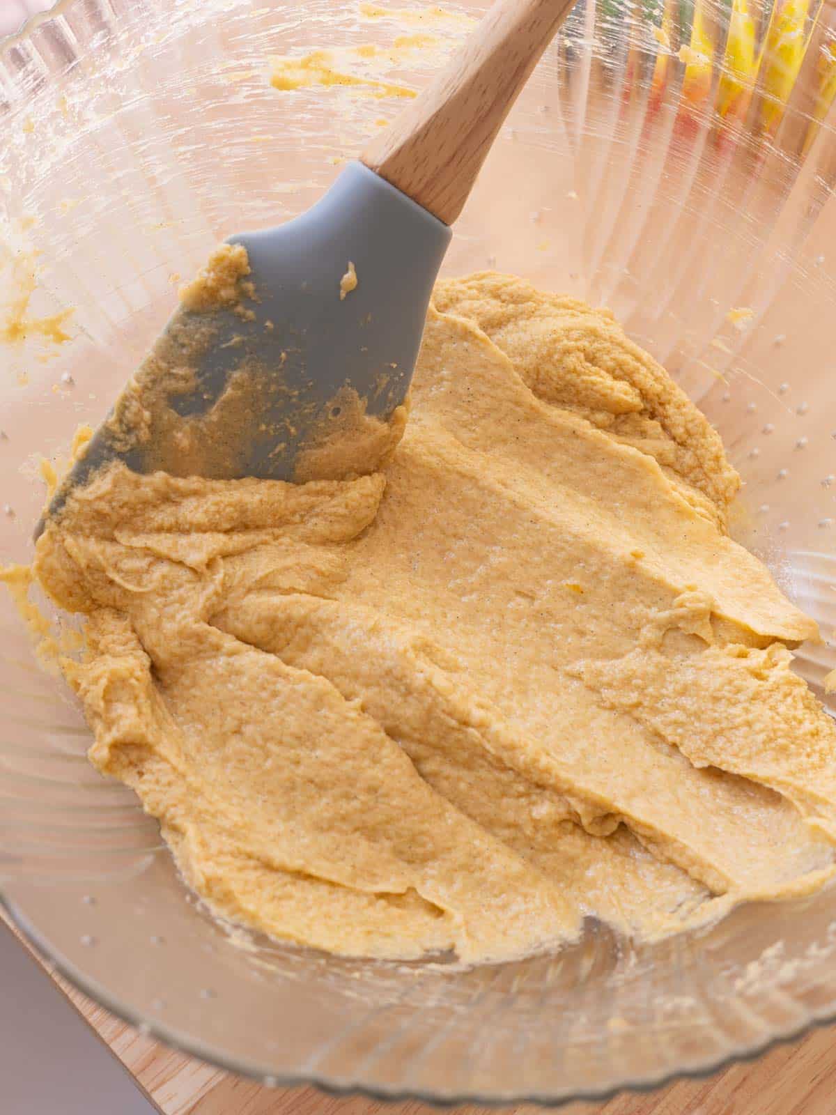 Glass mixing bowl with creamed butter and sugars.