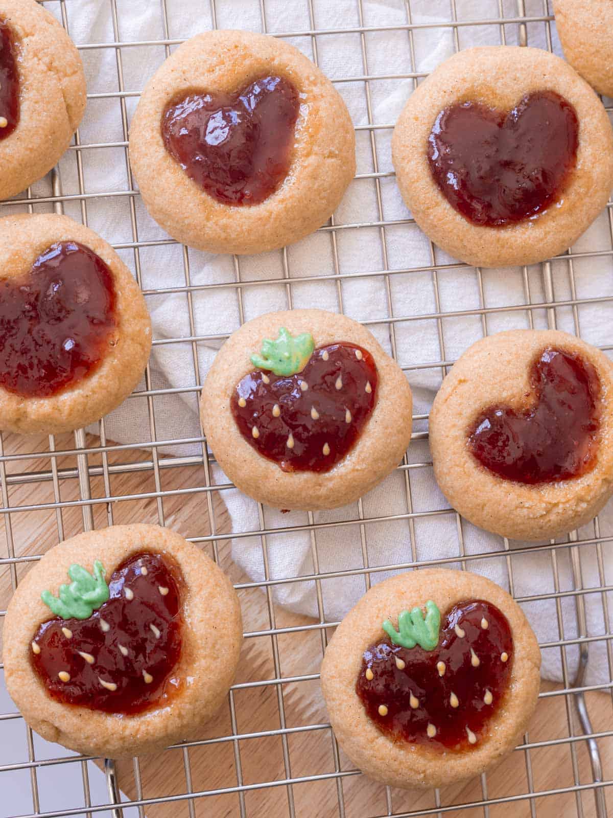 Decorated strawberry thumbprint cookies that look like strawberries in the middle.