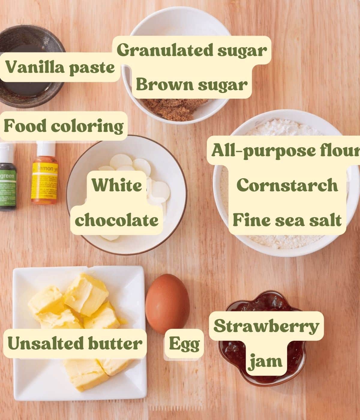 Strawberry thumbprint cookie labeled ingredients laid out on a wooden table.